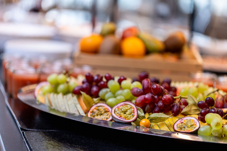 Schön angerichtete üppige Obstplatten aus Weintrauben, Maracujahälften, Orangen, und aufgeschnittene Melone